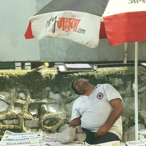 A sleeping newspaper vendor…