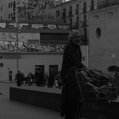 Homeless man carrying a trolley