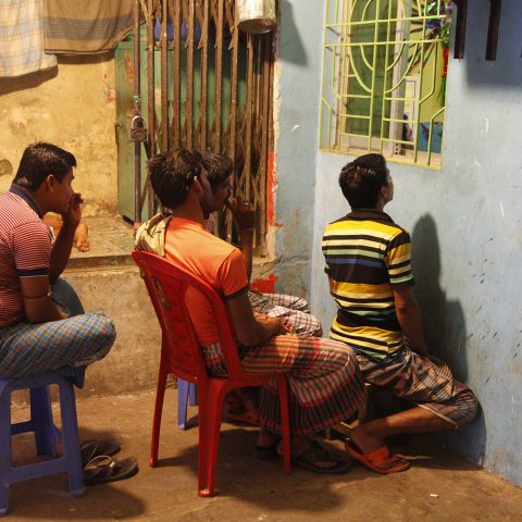 Men watching TV through a small window.